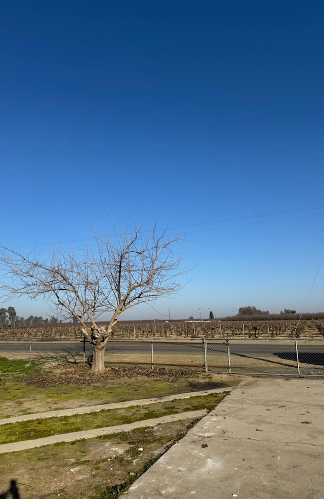 view of yard with a gate, a rural view, and fence