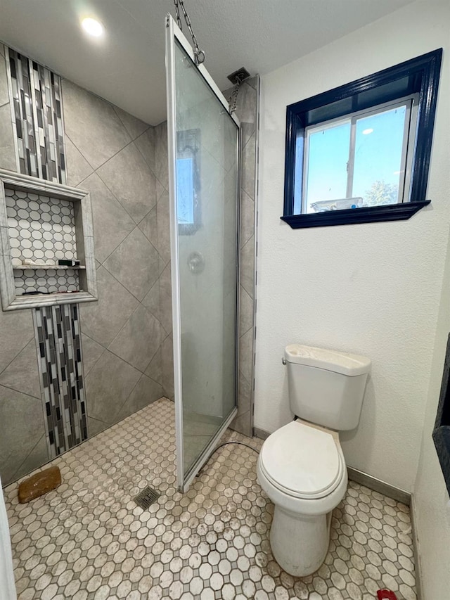 bathroom featuring baseboards, tiled shower, and toilet