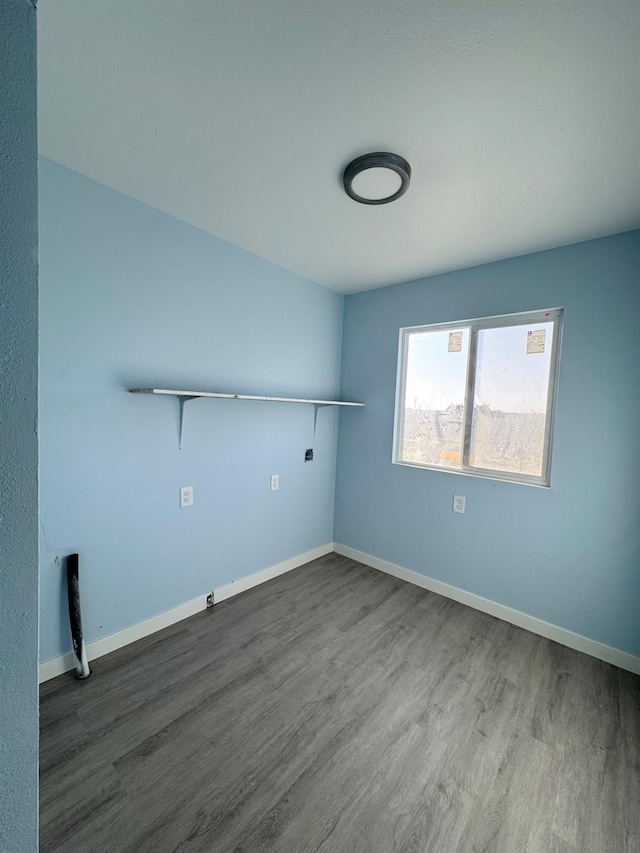 washroom with laundry area, baseboards, and wood finished floors