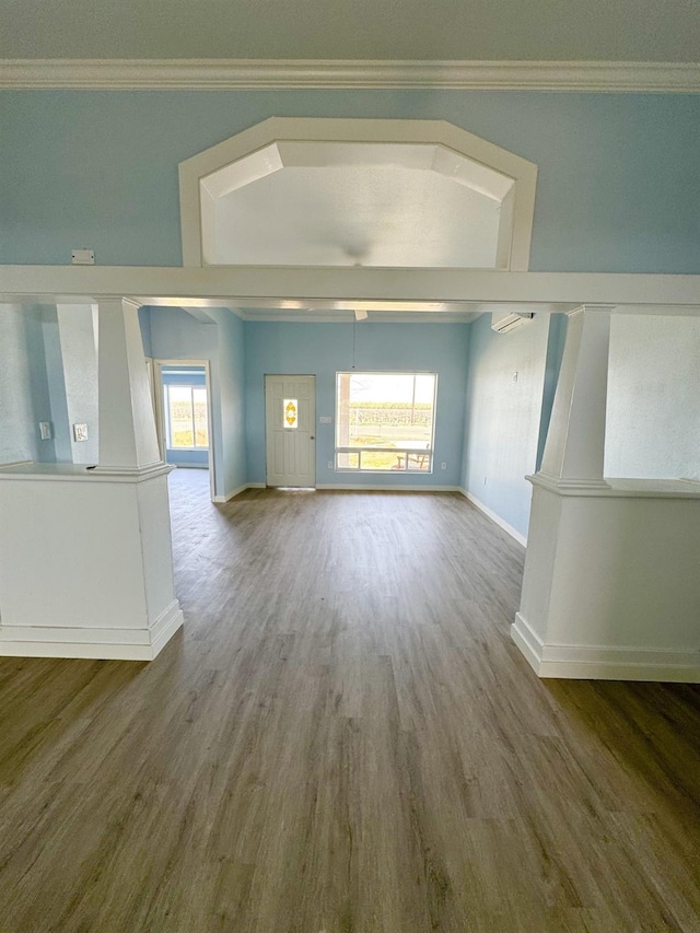 unfurnished living room featuring baseboards, wood finished floors, and ornamental molding