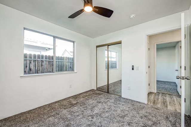 unfurnished bedroom with carpet floors, ceiling fan, and a closet