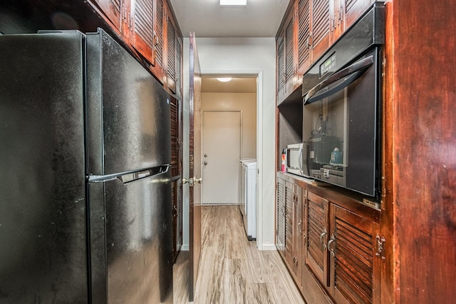 kitchen with black appliances and light hardwood / wood-style floors