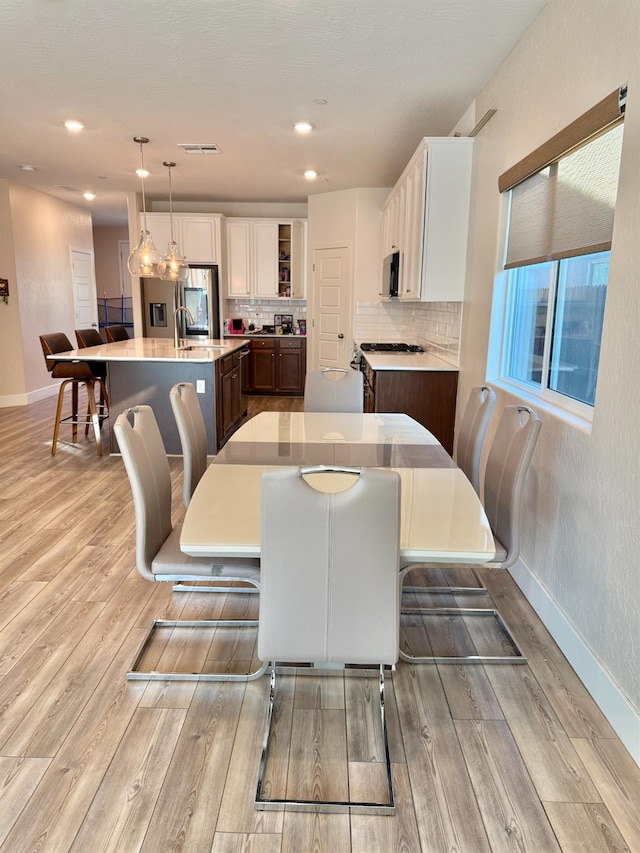 dining area featuring sink and light wood-type flooring