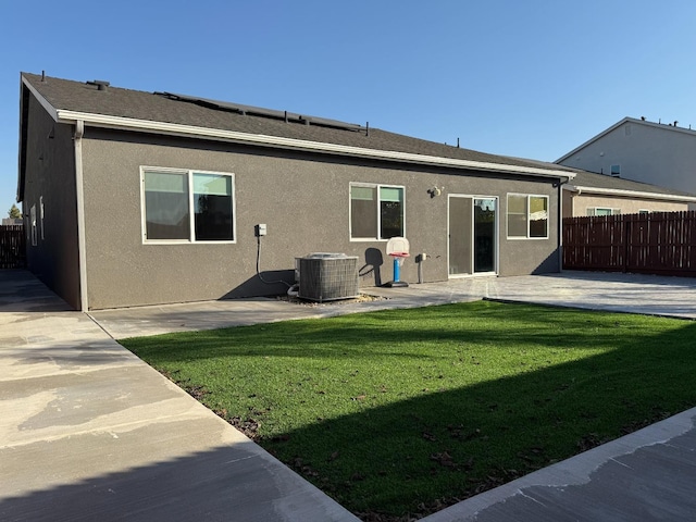 rear view of house featuring central AC unit, a lawn, and a patio