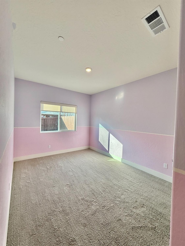 spare room with a textured ceiling and carpet