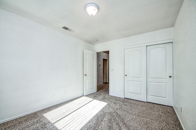 unfurnished bedroom with carpet flooring and a closet