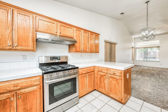 kitchen featuring decorative light fixtures, light carpet, stainless steel gas stove, kitchen peninsula, and vaulted ceiling