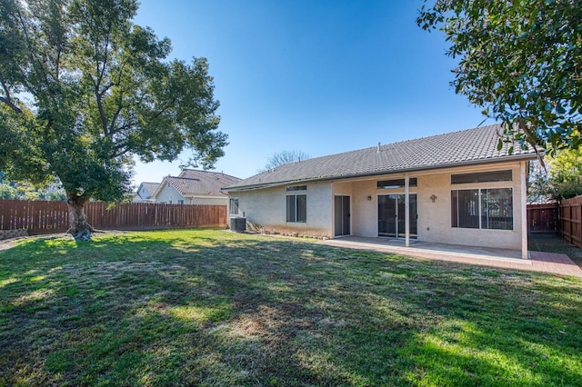 rear view of property featuring cooling unit, a patio, and a yard