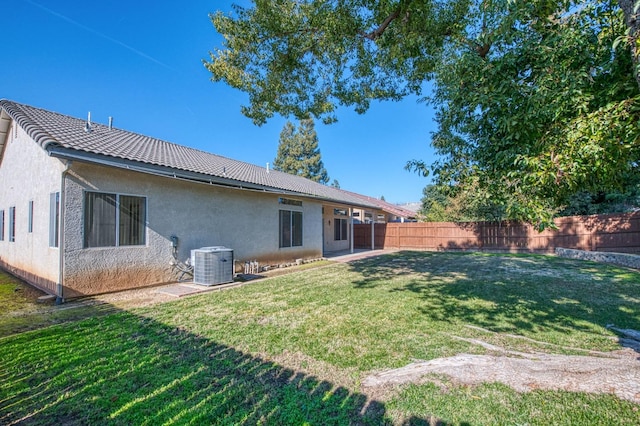 back of house featuring a lawn and central AC