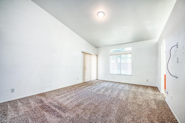 unfurnished room with carpet flooring and vaulted ceiling