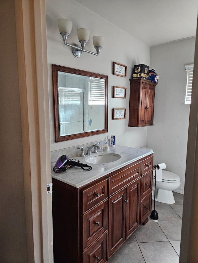 bathroom featuring vanity, tile patterned floors, and toilet