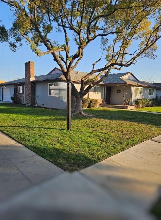 ranch-style house with a garage and a front yard