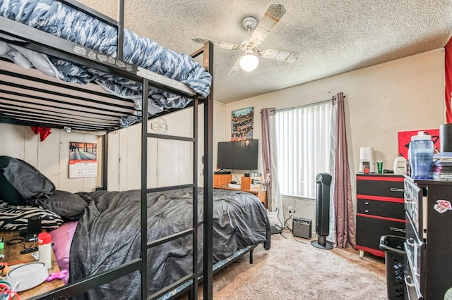 carpeted bedroom with ceiling fan and a textured ceiling