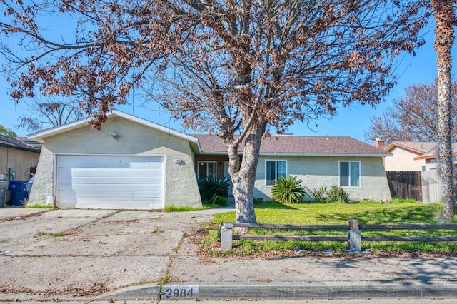 ranch-style home featuring a garage and a front lawn