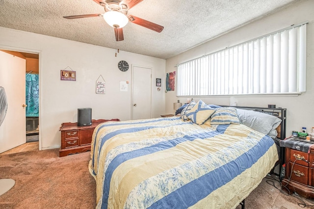 bedroom featuring ceiling fan, light colored carpet, and a textured ceiling