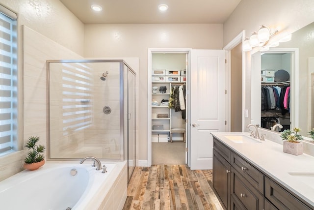 bathroom with vanity, hardwood / wood-style floors, and plus walk in shower