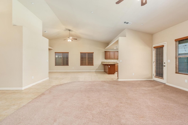 unfurnished living room with ceiling fan, light tile patterned floors, and vaulted ceiling