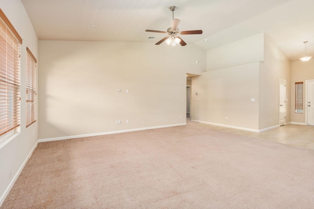 spare room with ceiling fan, high vaulted ceiling, and light carpet