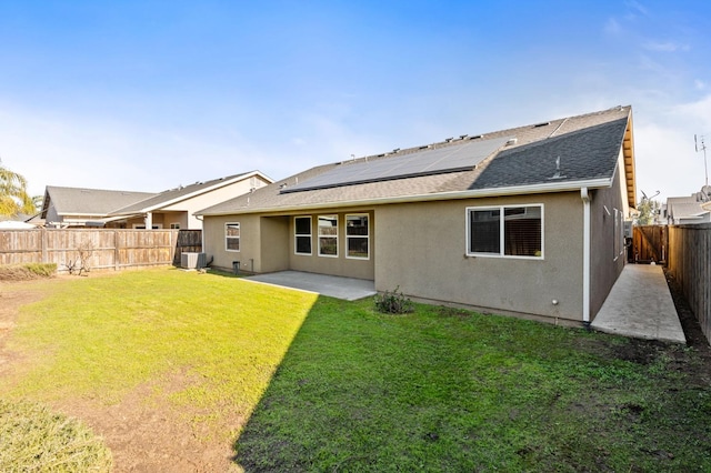 back of property featuring a yard, a patio area, central AC unit, and solar panels