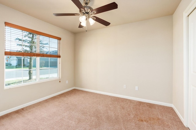 carpeted spare room with ceiling fan