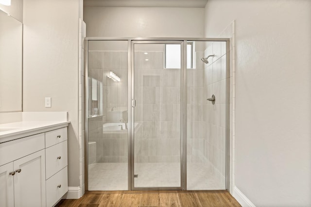 bathroom with an enclosed shower, wood-type flooring, vanity, and french doors