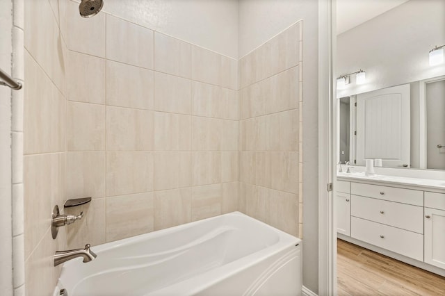 bathroom with tiled shower / bath, vanity, and hardwood / wood-style floors