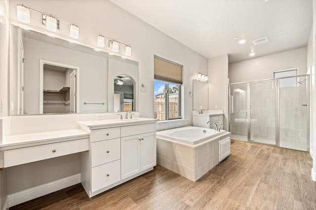 bathroom with vanity, hardwood / wood-style flooring, plus walk in shower, and ceiling fan