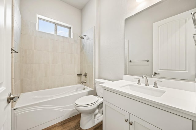 full bathroom with vanity, hardwood / wood-style floors, toilet, and tiled shower / bath