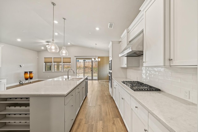 kitchen featuring range hood, white cabinets, hanging light fixtures, stainless steel appliances, and a spacious island