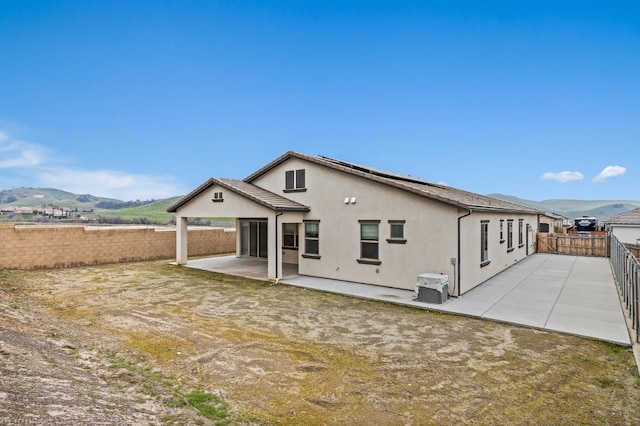 rear view of property with a mountain view, a patio area, and central air condition unit