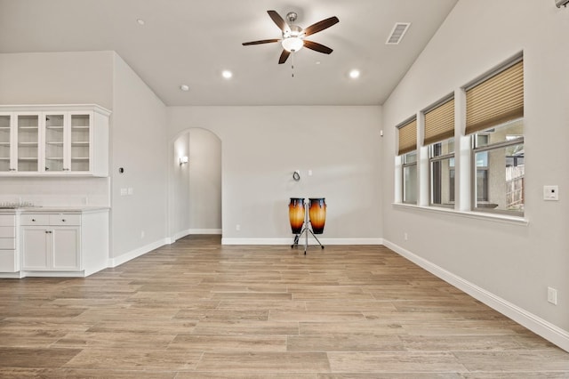 unfurnished living room with lofted ceiling, ceiling fan, and light hardwood / wood-style flooring