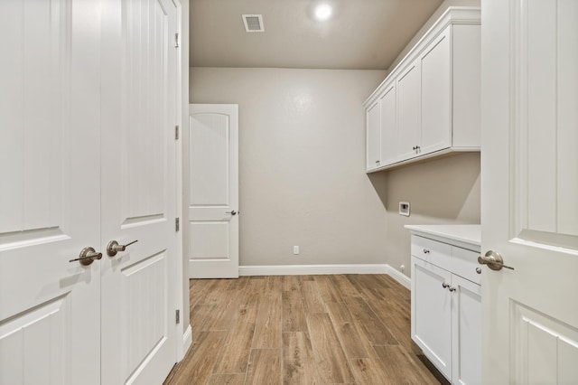 laundry area with light hardwood / wood-style flooring, cabinets, and hookup for an electric dryer