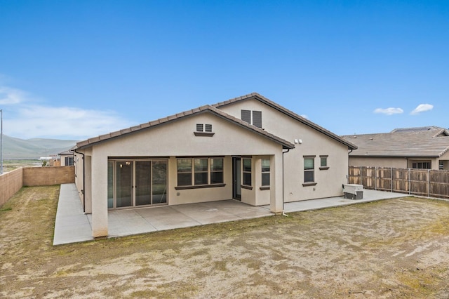 rear view of house featuring a mountain view and a patio area