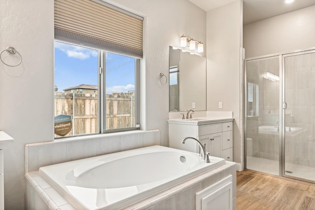 bathroom featuring vanity, plus walk in shower, and wood-type flooring