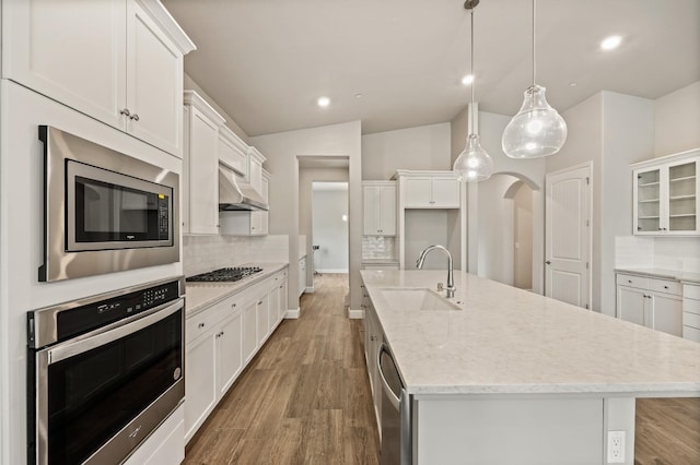 kitchen with sink, hanging light fixtures, white cabinets, and appliances with stainless steel finishes