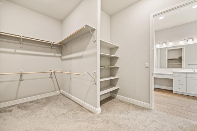 walk in closet featuring light colored carpet