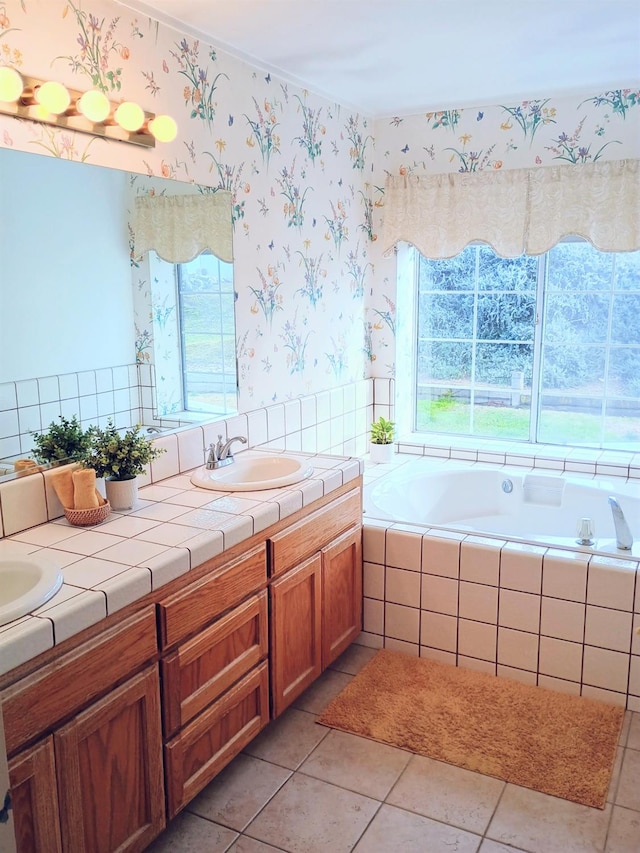 bathroom with tiled tub, vanity, and tile patterned floors