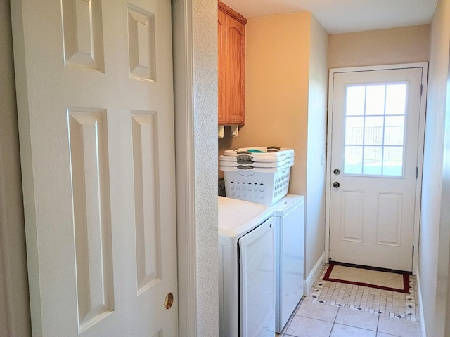 laundry room with cabinets, light tile patterned floors, and washer and clothes dryer