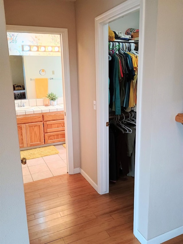interior space featuring light wood finished floors, baseboards, and a sink