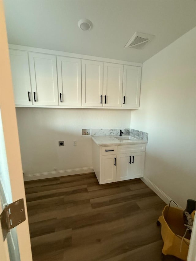 clothes washing area featuring sink, hookup for a washing machine, hookup for an electric dryer, cabinets, and dark hardwood / wood-style floors