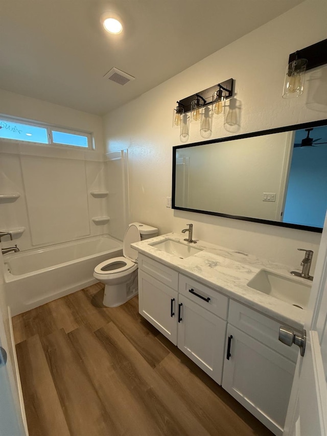 full bathroom with hardwood / wood-style flooring, toilet, bathtub / shower combination, and vanity