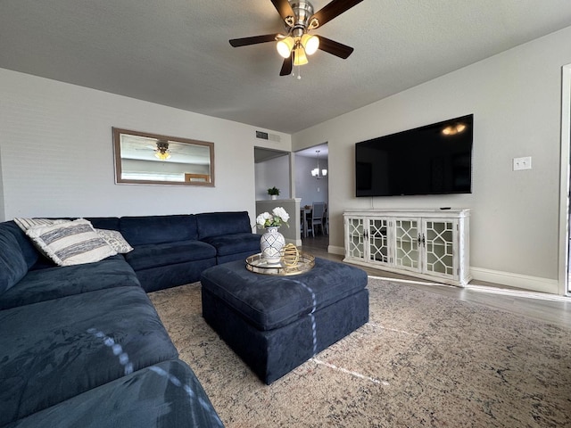 living room featuring ceiling fan and a textured ceiling