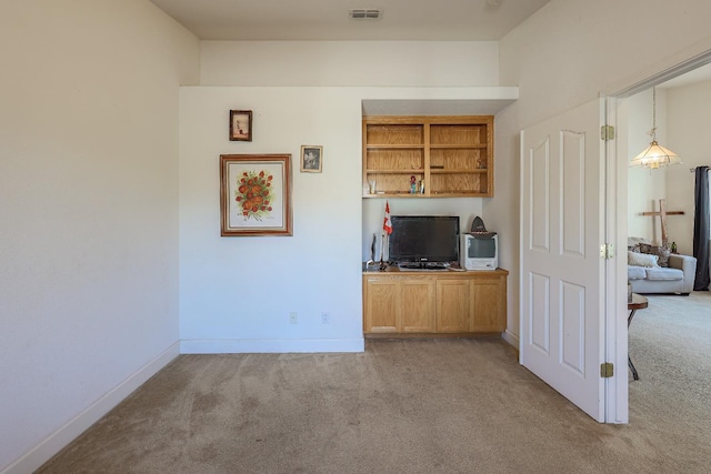 unfurnished living room with built in features and light colored carpet