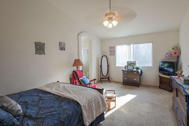 bedroom with ceiling fan, light colored carpet, and vaulted ceiling