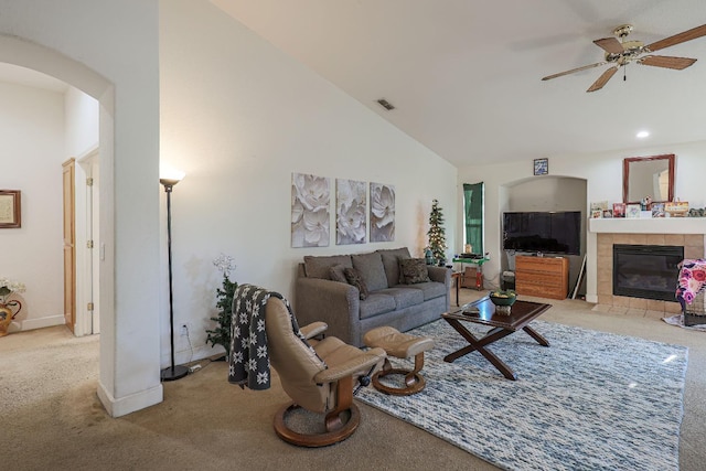 carpeted living room featuring ceiling fan, high vaulted ceiling, and a fireplace