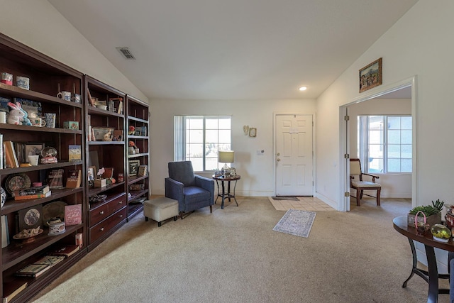 living area with light colored carpet and vaulted ceiling