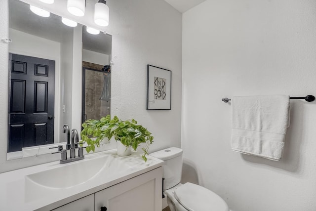 bathroom featuring a shower, toilet, and vanity