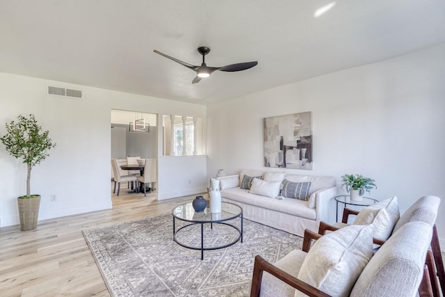 living room with ceiling fan and light hardwood / wood-style flooring