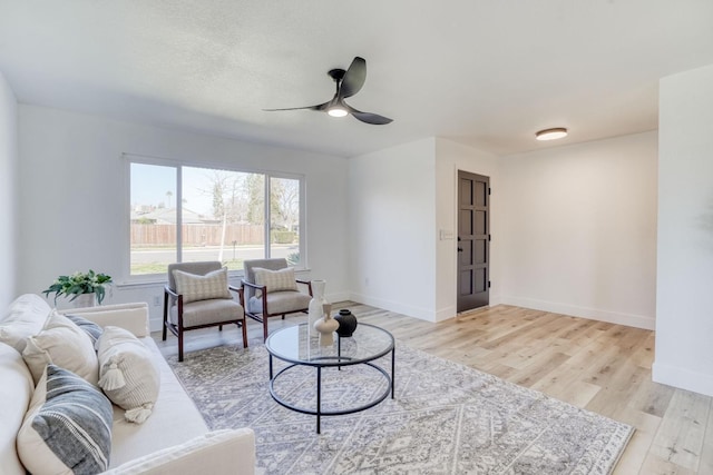 living room featuring ceiling fan and light hardwood / wood-style flooring