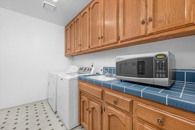 laundry room with independent washer and dryer and cabinets